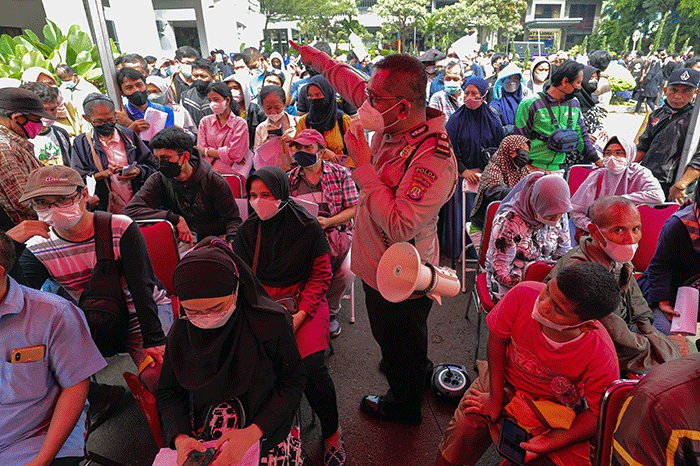 Warga menunjukkan tiket mudik gratis Lebaran 2022 di depan Gedung Balai Pertemuan Metro Jaya, Polda Metro Jaya, Jakarta Selatan, Sabtu (23/4/2022).