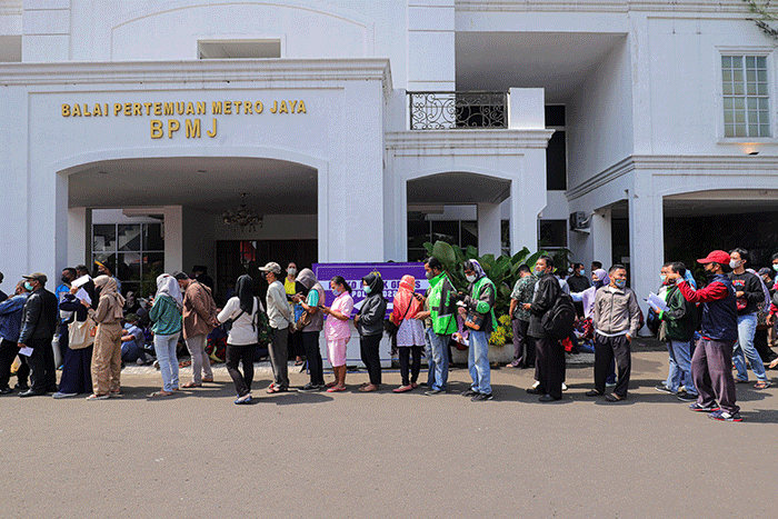 Warga menunjukkan tiket mudik gratis Lebaran 2022 di depan Gedung Balai Pertemuan Metro Jaya, Polda Metro Jaya, Jakarta Selatan, Sabtu (23/4/2022).