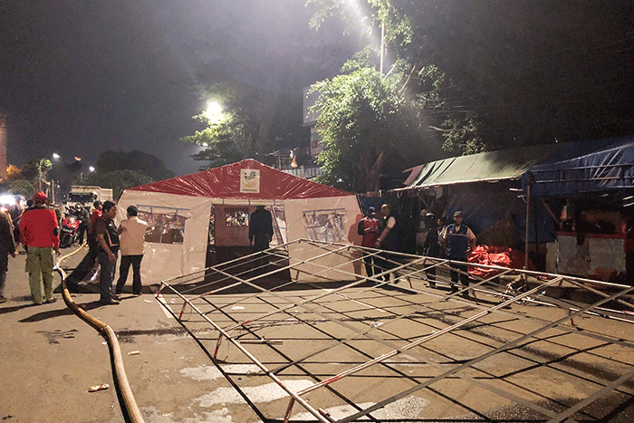 Petugas pemadam kebakaran bersama petugas Palang Merah Indonesia mendirikan tenda darurat untuk warga yang menjadi korban kebakaran di kawasan Pasar Gembrong.