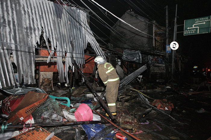 Petugas pemadam kebakaran berusaha memadamkan kobaran api yang membakar kios dan rumah warga di kawasan Pasar Gembrong, Jatinegara, Jakarta Timur.