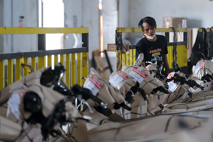 Petugas mengemas motor sebelum dikirim menggunakan kereta di Stasiun Kereta Api Logistik, Kampung Bandan, Jakarta Utara, Selasa (26/4/2022).