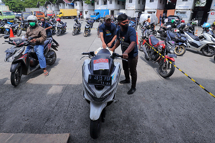 Petugas mengemas motor sebelum dikirim menggunakan kereta di Stasiun Kereta Api Logistik, Kampung Bandan, Jakarta Utara, Selasa (26/4/2022).