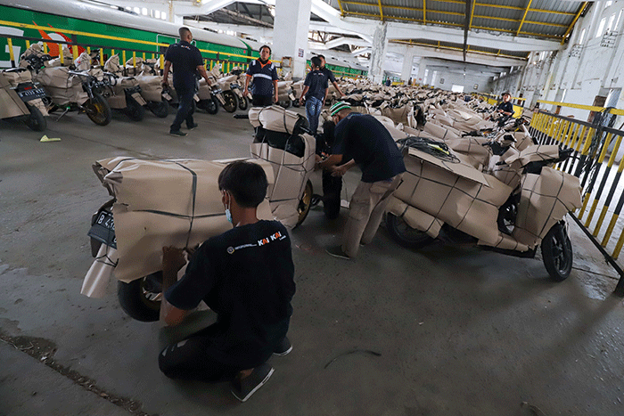 Petugas mengemas motor sebelum dikirim menggunakan kereta di Stasiun Kereta Api Logistik, Kampung Bandan, Jakarta Utara, Selasa (26/4/2022).