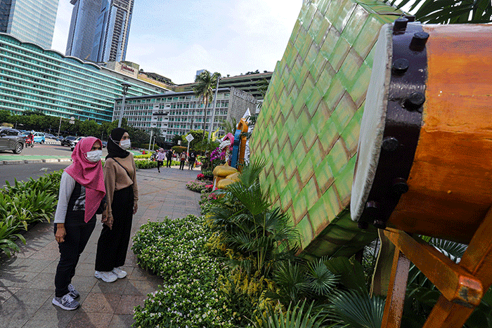Warga berswafoto dengan latar belakang ornamen bernuansa lebaran yang terpasang di kawasan Bundaran HI, Jakarta Pusat, Selasa (26/4/2022).