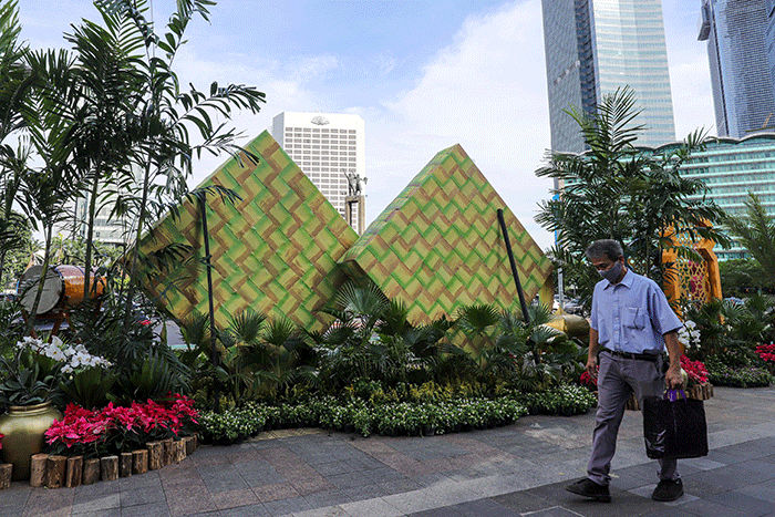 Warga berswafoto dengan latar belakang ornamen bernuansa lebaran yang terpasang di kawasan Bundaran HI, Jakarta Pusat, Selasa (26/4/2022).