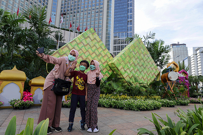 Warga berswafoto dengan latar belakang ornamen bernuansa lebaran yang terpasang di kawasan Bundaran HI, Jakarta Pusat, Selasa (26/4/2022).