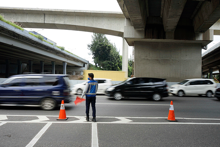 Petugas mengatur lalu lintas di depan pintu masuk tol layang MBZ yang ditutup situasional, Bekasi, Jawa Barat, Kamis (28/4/2022).