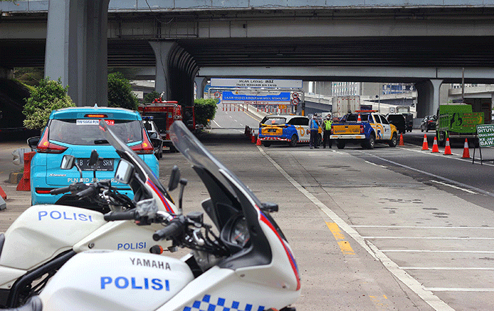 Petugas mengatur arus lalu lintas didekat pintu masuk Jalan Tol Layang Mohammed Bin (MBZ), Jakarta-Cikampek di kawasan Jatibening, Bekasi, Jawa Barat.