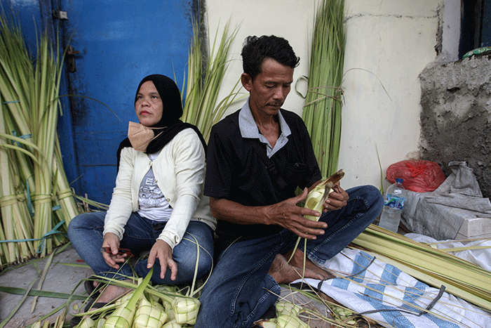 Pedagang musiman saat membuat anyaman kulit ketupat di Pasar Pondok Gede, Bekasi, Jawa Barat, Sabtu (30/4/2022).