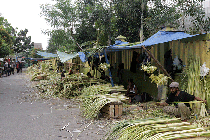 Pedagang musiman saat membuat anyaman kulit ketupat di Pasar Pondok Gede, Bekasi, Jawa Barat, Sabtu (30/4/2022).