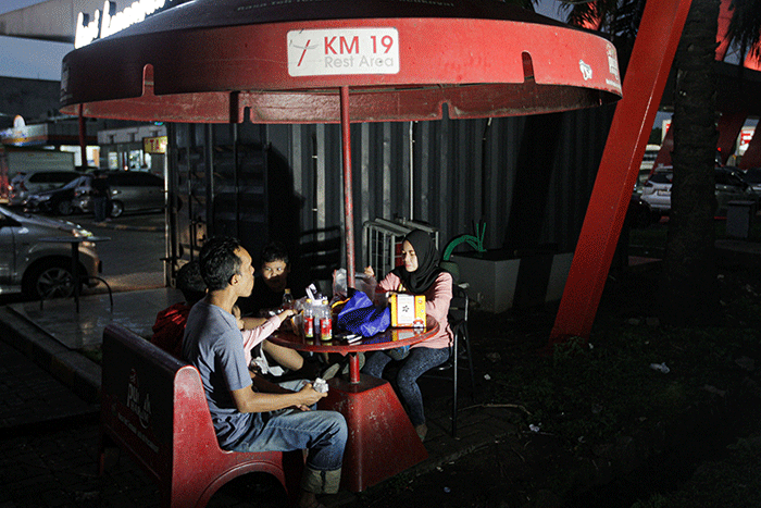 Sejumlah pemudik menyantap makanan berbuka puasa di Rest Area KM 19 ruas tol Jakarta-Cikampek, Jumat (29/4/2022).