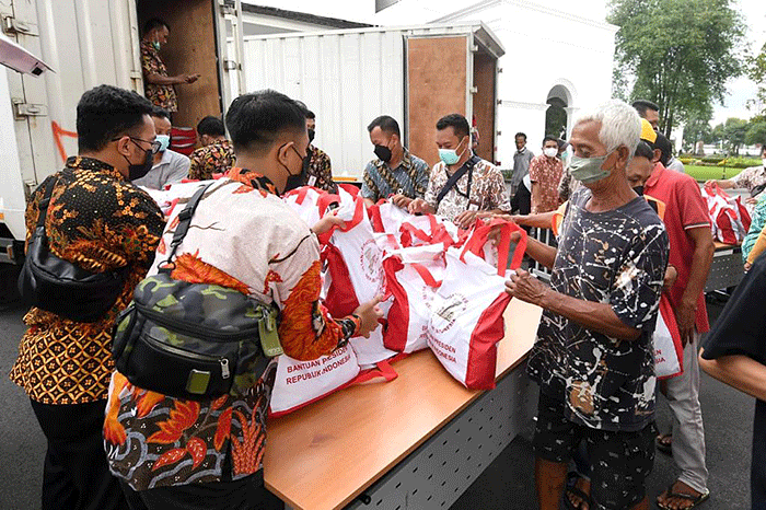 Presiden Joko Widodo membagikan paket sembako bagi masyarakat di sekitar Gedung Agung, Istana Kepresidenan Yogyakarta, pada Sabtu, 30 April 2022.