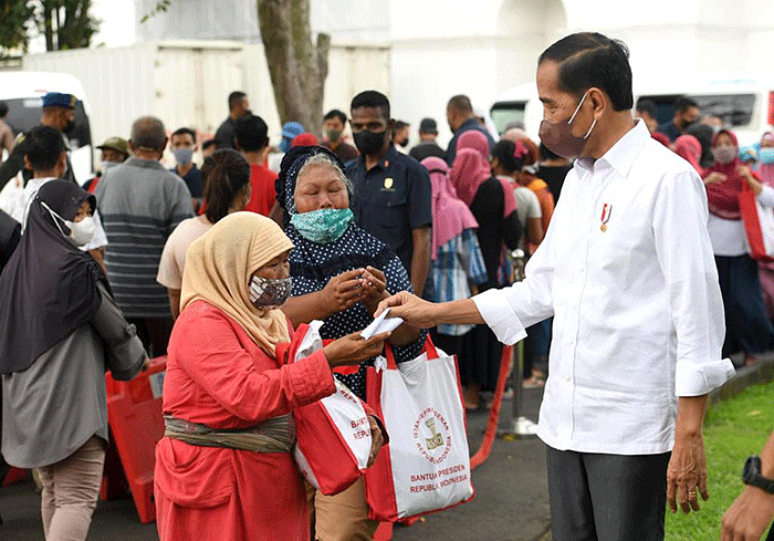 Presiden Joko Widodo membagikan paket sembako bagi masyarakat di sekitar Gedung Agung, Istana Kepresidenan Yogyakarta, pada Sabtu, 30 April 2022.