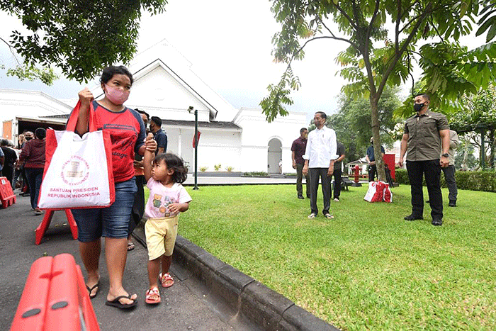 Presiden Joko Widodo membagikan paket sembako bagi masyarakat di sekitar Gedung Agung, Istana Kepresidenan Yogyakarta, pada Sabtu, 30 April 2022.