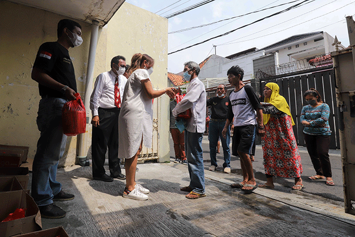 Ketua Gerkindo Jakarta Timur Sandra Charlotte saat membagikan bingkisan kepada warga di Jalan Jatinegara Barat 4, Jakarta Timur, Minggu (1/5/2022).