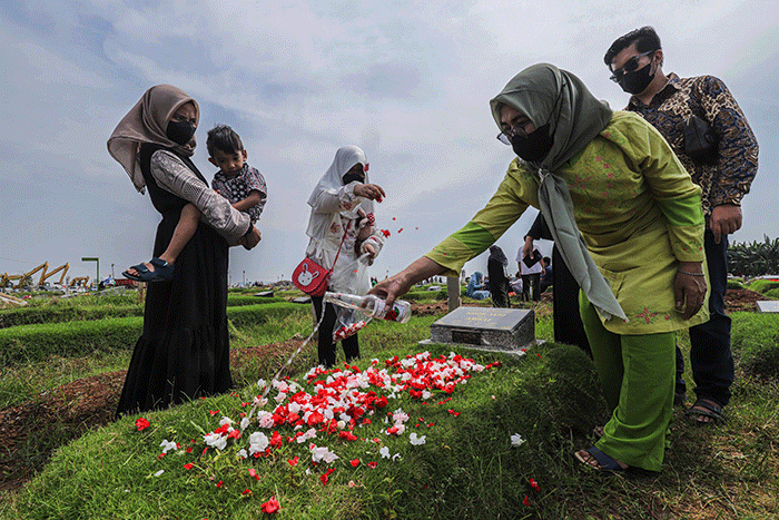 Umat muslim berdoa di dekat makam keluarganya saat melakukan ziarah kubur di Blok Syuhada, Tempat Pemakaman Umum (TPU) Rorotan, Jakarta Utara, Senin (2/5/2022).