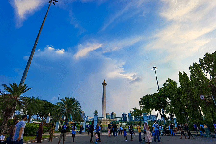 Warga berfoto di halaman luar Monumen Nasional (Monas) Jakarta, Kamis (5/5/2022).