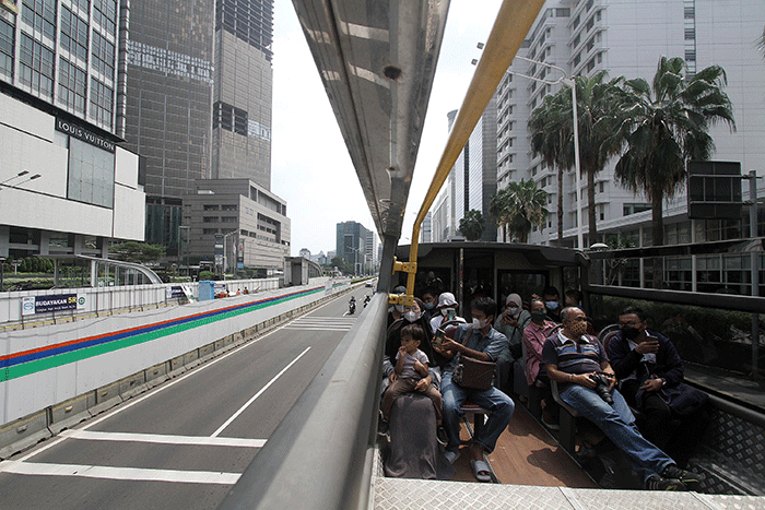 Warga menikmati pemandangan Jakarta dari bus tingkat Transjakarta wisata dengan atap terbuka, Rabu (11/5/2022).