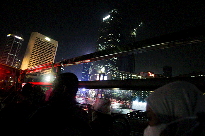 Warga menikmati keindahan kota Jakarta pada malam hari dari atas bus wisata Transjakarta di kawasan Jakarta, Rabu (11/5/2022).