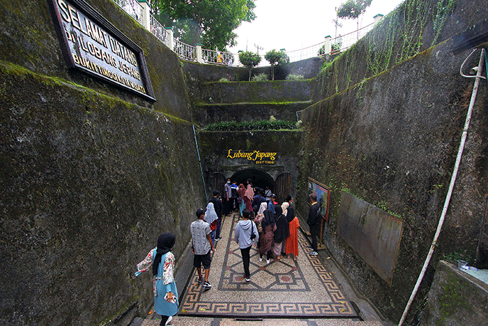 Pengunjung berada di depan pintu masuk Lobang Jepang di kompleks wisata Ngarai Sianok yang berlokasi di Jalan Panorama, Bukit Cangang Kayu Ramang, Bukittinggi.