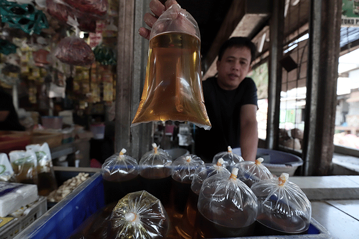 Pedagang menunjukkan minyak goreng curah disalah satu toko di kawasan Kota Bekasi, Jawa Barat, Senin (16/5/2022).