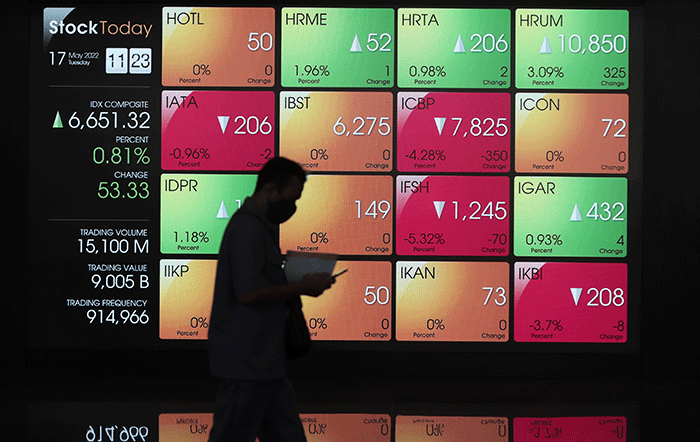 Pengunjung melintas di layar Pergerakan Indeks Harga Saham Gabungan (IHSG), BEI, Selasa (17/5/2022).