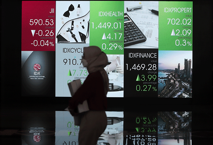 Pengunjung melintas di layar Pergerakan Indeks Harga Saham Gabungan (IHSG), BEI, Selasa (17/5/2022).