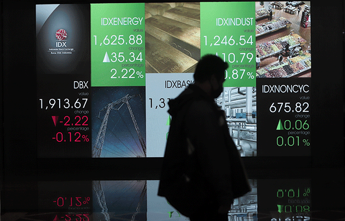 Pengunjung melintas di layar Pergerakan Indeks Harga Saham Gabungan (IHSG), BEI, Selasa (17/5/2022).