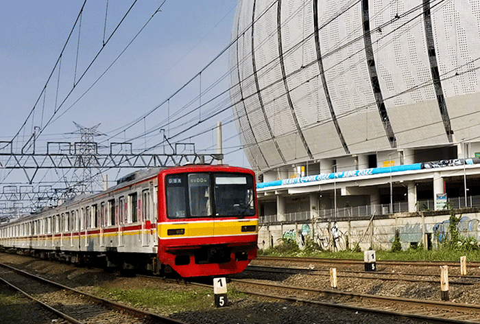 KRL Commuterline saat melintas dengan berlatar belakang gedung Jakarta International Stadium, Jakarta Utara, Rabu, (18/5/2022).