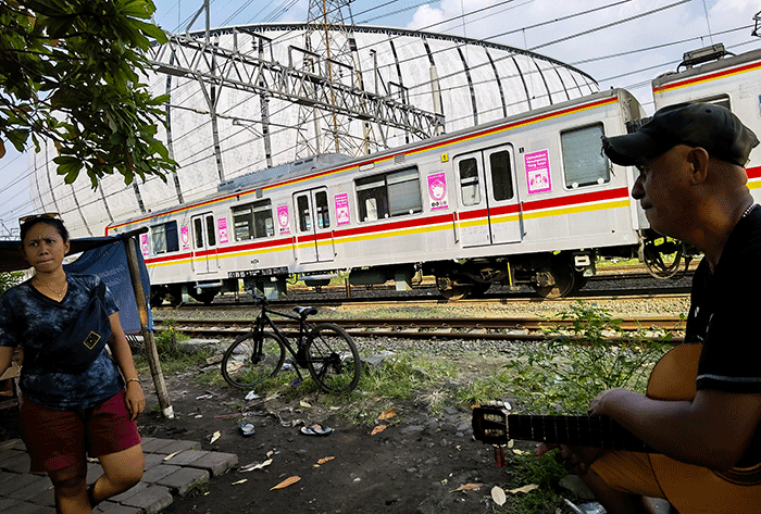 KRL Commuterline saat melintas dengan berlatar belakang gedung Jakarta International Stadium, Jakarta Utara, Rabu, (18/5/2022).