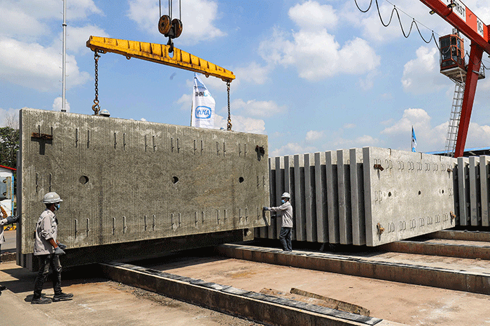 Pekerja membersikan slab track atau bantalan rel menggunakan terpal di Pabrik Slab Track PT Wika Beton, Karawang, Jawa Barat, Rabu (18/5/2022).
