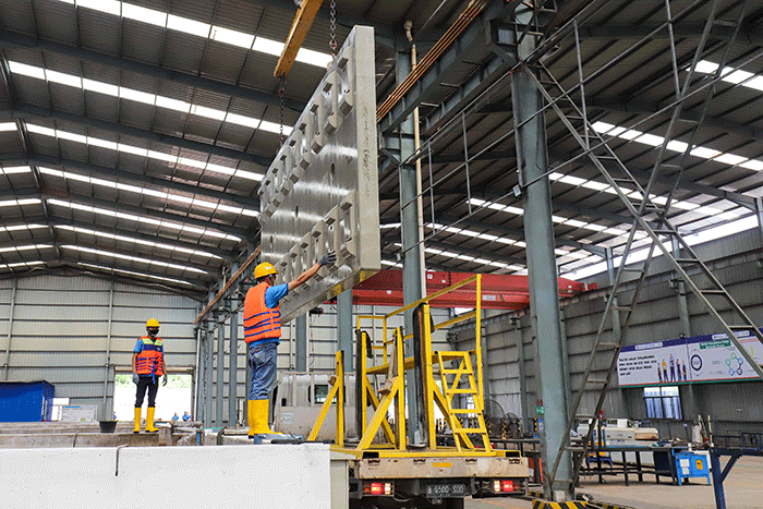 Pekerja membersikan slab track atau bantalan rel menggunakan terpal di Pabrik Slab Track PT Wika Beton, Karawang, Jawa Barat, Rabu (18/5/2022).