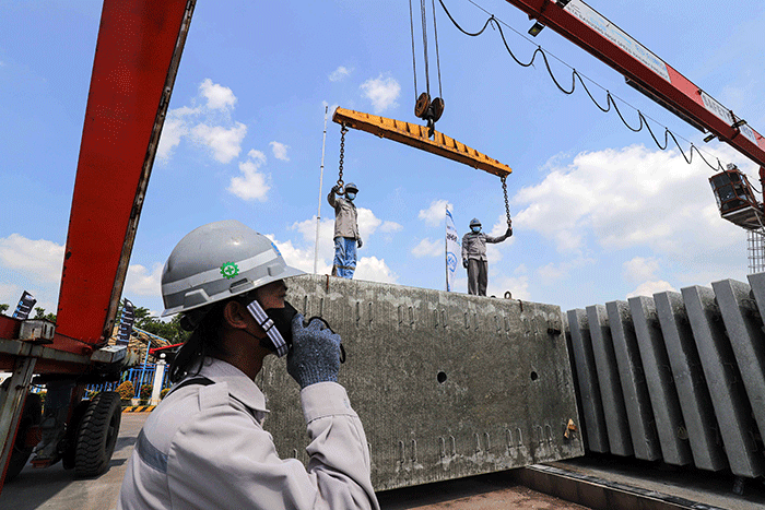 Pekerja membersikan slab track atau bantalan rel menggunakan terpal di Pabrik Slab Track PT Wika Beton, Karawang, Jawa Barat, Rabu (18/5/2022).