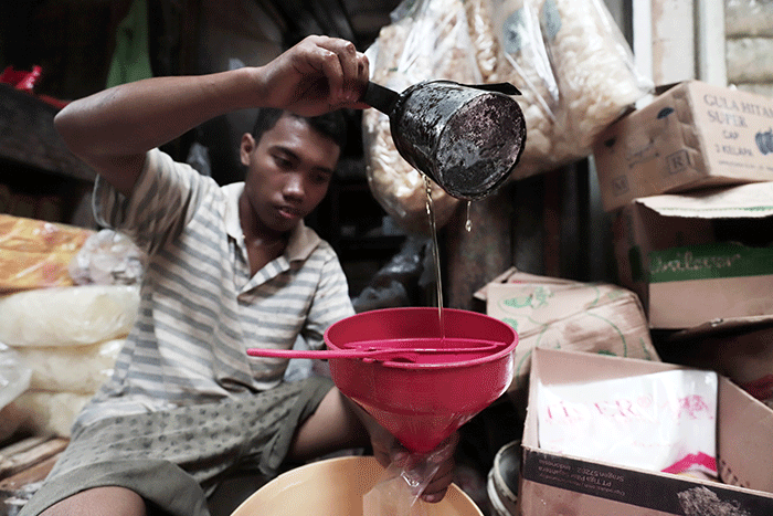 Pedagang mengemas minyak goreng curah di Pasar Kecapi, Kota Bekasi, Jawa Barat, Rabu (18/5/2022).