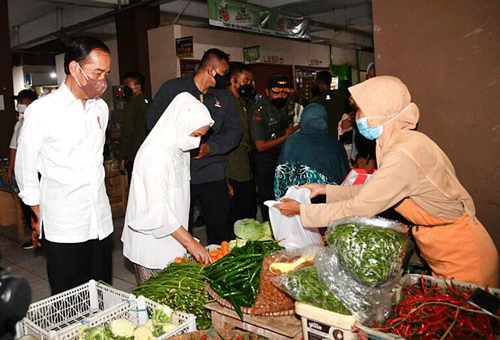 Presiden Joko Widodo didampingi Ibu Negara Iriana Joko Widodo menyapa warga saat mengunjungi Pasar Muntilan, Magelang, Jawa Tengah, Sabtu (21/5/2022).
