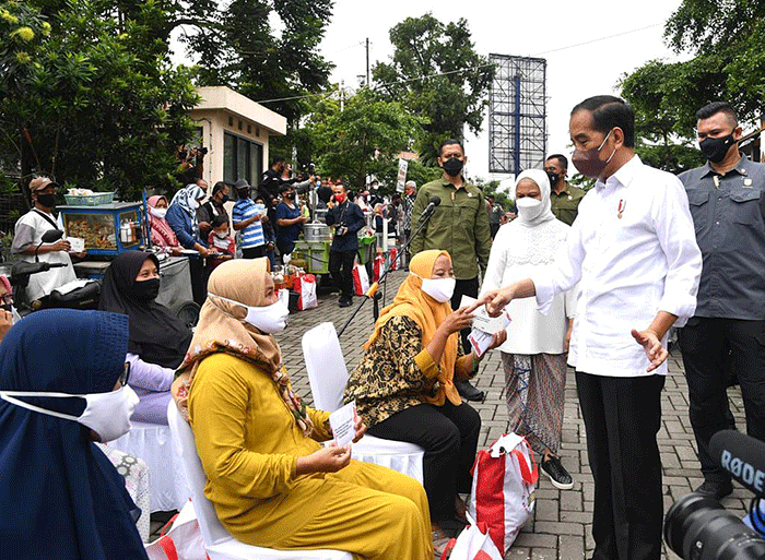 Presiden Joko Widodo didampingi Ibu Negara Iriana Joko Widodo menyapa warga saat mengunjungi Pasar Muntilan, Magelang, Jawa Tengah, Sabtu (21/5/2022).