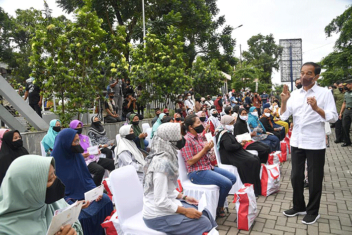 Presiden Joko Widodo didampingi Ibu Negara Iriana Joko Widodo menyapa warga saat mengunjungi Pasar Muntilan, Magelang, Jawa Tengah, Sabtu (21/5/2022).