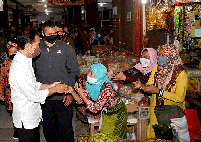 Presiden Joko Widodo didampingi Ibu Negara Iriana Joko Widodo menyapa warga saat mengunjungi Pasar Muntilan, Magelang, Jawa Tengah, Sabtu (21/5/2022).