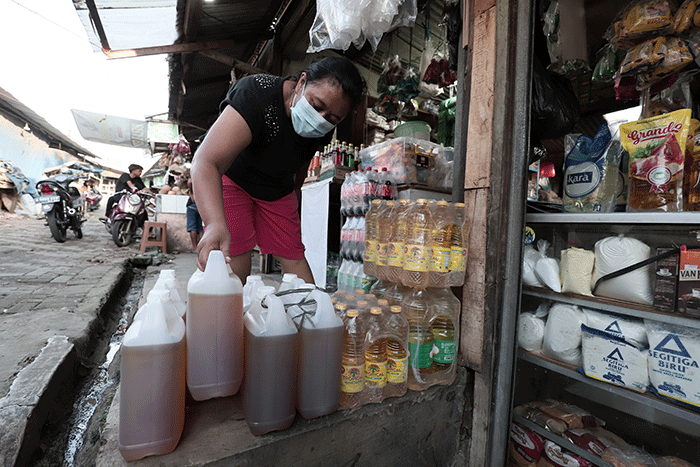 Pedagang menunjukkan minyak goreng curah disalah satu toko kawasan Pondok Melati, Kota Bekasi, Jawa Barat, Senin (23/5/2022).