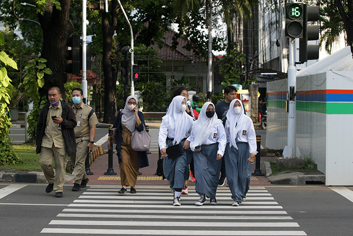 Sejumlah pekerja menyeberang jalan saat jam pulang kerja di kawasan Jalan Merdeka Selatan, Jakarta Pusat, Selasa (24/5/2022).