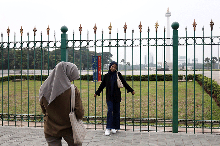 Warga berfoto dengan latar belakang Monumen Nasional di Jakarta, Kamis (26/5/2022).