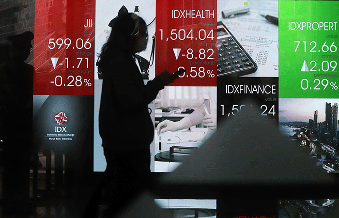 Pekerja melintasi layar pergerakan Indeks Harga Saham Gabungan (IHSG) di Bursa Efek Indonesia, Jakarta Selatan, Senin (30/5/2022).