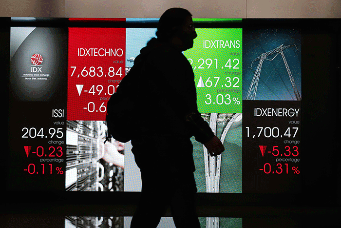 Pekerja melintasi layar pergerakan Indeks Harga Saham Gabungan (IHSG) di Bursa Efek Indonesia, Jakarta Selatan, Senin (30/5/2022).