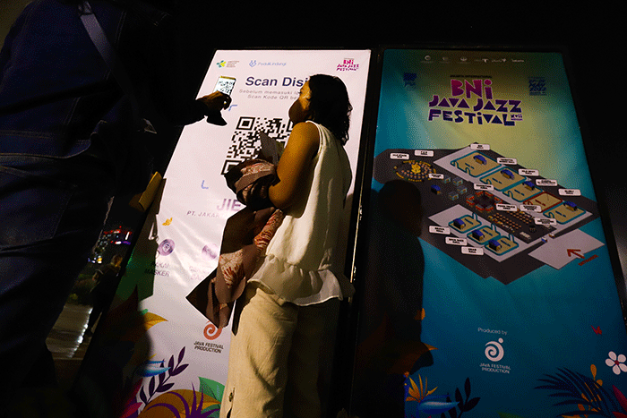 Sejumlah penonton yang akan memasuki arena pertunjukan musik BNI Java Jazz Festival 2022 melakukan scan Aplikasi PeduliLindungi sebagai protokol kesehatan.