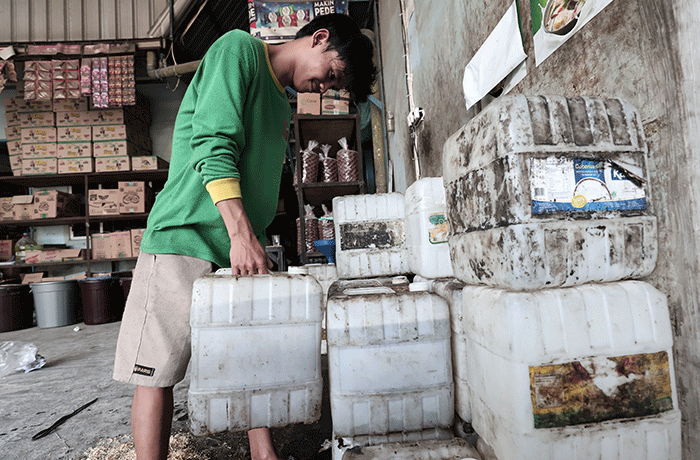 Pekerja menunjukkan minyak goreng curah di salah satu agen kawasan Pondok Melati, Kota Bekasi, Jawa Barat, Selasa (31/5/2022).