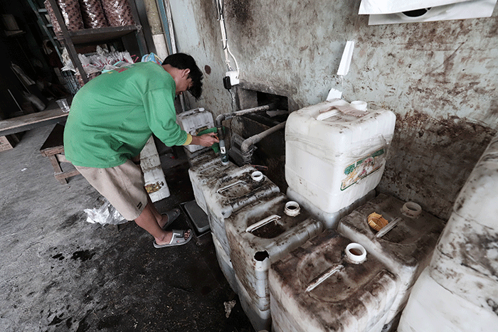 Pekerja menunjukkan minyak goreng curah di salah satu agen kawasan Pondok Melati, Kota Bekasi, Jawa Barat, Selasa (31/5/2022).