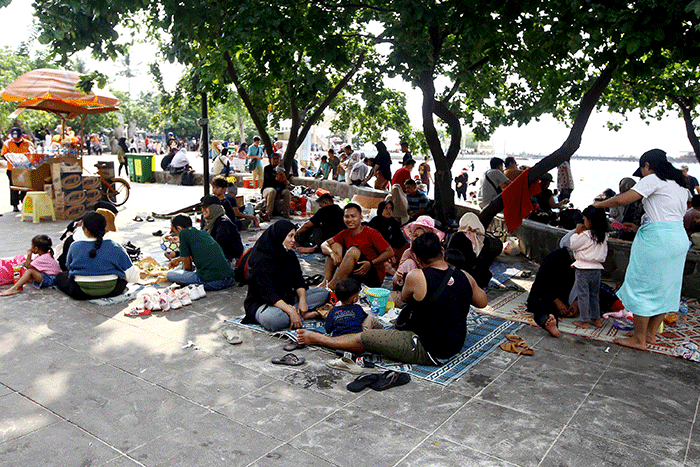 Warga berlibur di Pantai Ancol, Jakarta Utara, Rabu (1/6/2022).