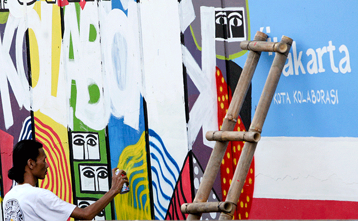 Warga menyelesaikan mural di salah satu dinding jalan yang berada di kawasan Jalan RE Martadinata, Jakarta Utara, Rabu, (1/6/2022).