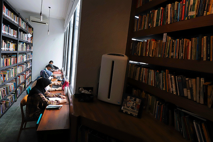 Pengunjung membaca buku di perpustakaan 