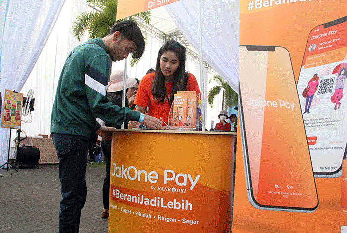 Pengunjung sedang bertransaksi menggunakan aplikasi JakOne Pay di salah satu pedagang binaan JakPreneur pada perhelatan Jakarta E-Prix 2022.